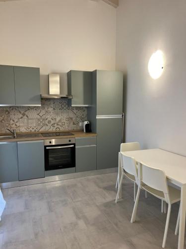 a kitchen with a table and a white table and chairs at Luciano Home in Gonnesa