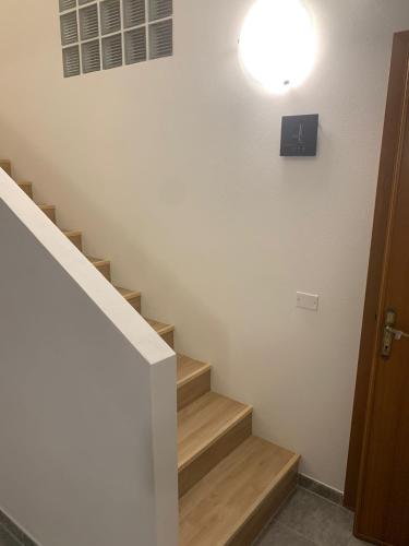 a hallway with stairs with a light on the wall at Luciano Home in Gonnesa