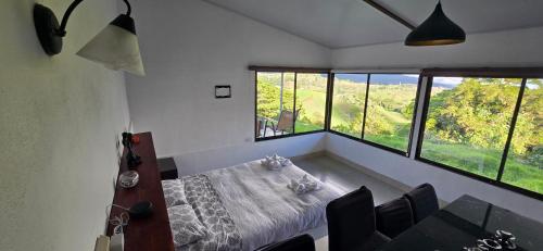 a dining room with a table and some windows at Volcano Panoramic Views in Vara Blanca