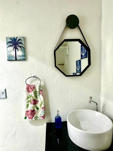 a bathroom with a sink and a mirror on the wall at Suíte 1 - Village Capixaba in Gravatá