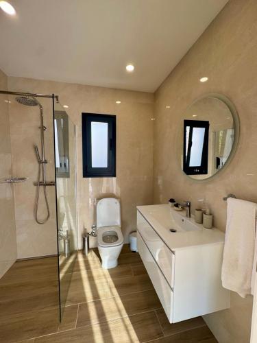 a bathroom with a toilet and a sink and a shower at Calheta Nest in Calheta