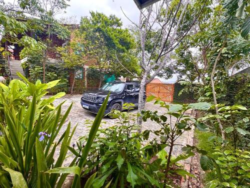 a black truck parked in a yard with a tree at Suíte 1 - Village Capixaba in Gravatá