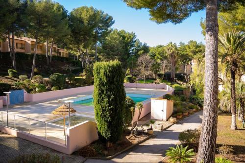 - une piscine dans une villa avec un arbre dans l'établissement Charmant studio à sanary - résidence avec piscine, à Sanary-sur-Mer