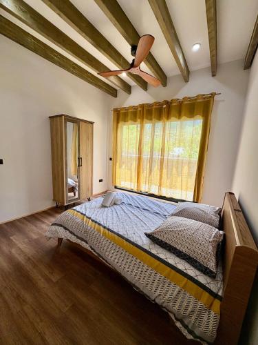 a bedroom with a large bed with a ceiling fan at Écrin du lac in Cilaos