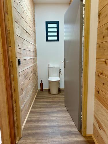 a hallway with a toilet in a room with wooden walls at Écrin du lac in Cilaos