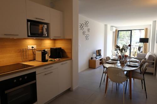 Il comprend une cuisine et une salle à manger avec une table et des chaises. dans l'établissement Appt T2, terrasse, Piscine, accès plage, à Pianottoli-Caldarello