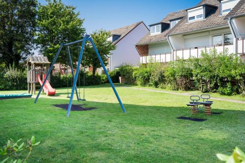 a playground with a swing set in a yard at Duhner Ausblick mit Balkon in Cuxhaven