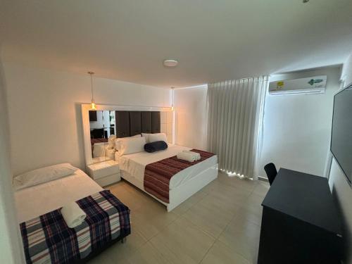 a hotel room with two beds and a mirror at Hotel Campestre Cerritos Plaza in Pereira