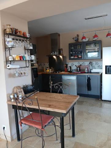 une cuisine avec une table en bois et une chaise rouge dans l'établissement villa panorama, à Vaison-la-Romaine