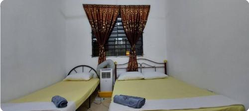 two beds in a room with a window at KK Minimalist Budget 2 Bedroom Appt f 6 free park in Penampang