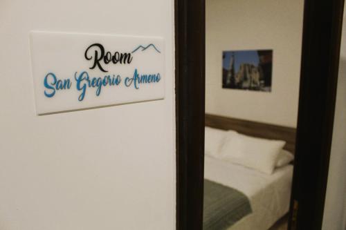 a room with a bed and a sign on a mirror at Punto Felice Riviera - Centro Città Lungomare Caracciolo in Naples