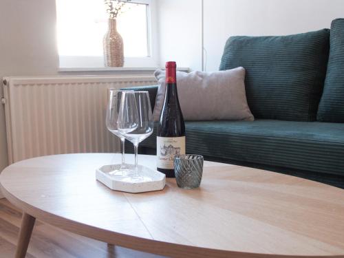 a bottle of wine and two glasses on a table at Förde Townhouse in Flensburg