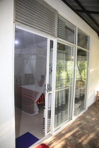 a sliding glass door of a house with a balcony at Evergreen Cottage in Ella
