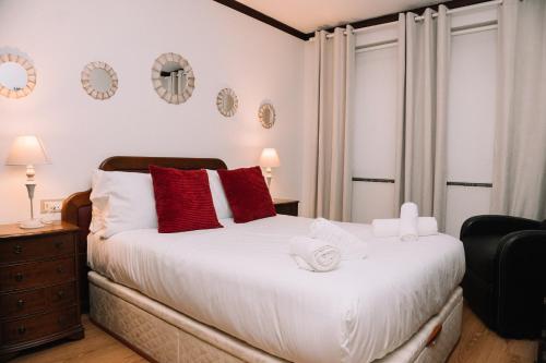 une chambre avec un grand lit blanc avec des oreillers rouges dans l'établissement Clásico en el centro de Vigo by CABANA Rentals, à Vigo