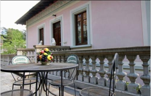 a table with chairs and a vase of flowers on a balcony at Charming & Luxury Villa Como Lake in Como