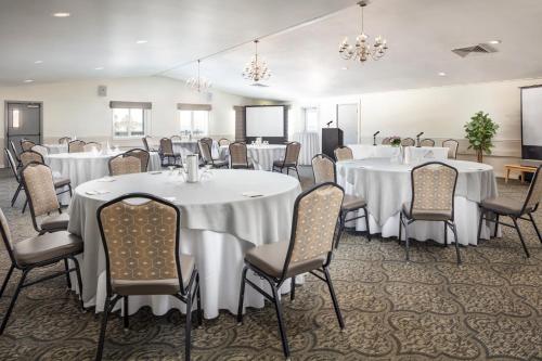 a banquet room with white tables and chairs and chandeliers at Atlantic Oceanside Hotel & Conference Center in Bar Harbor