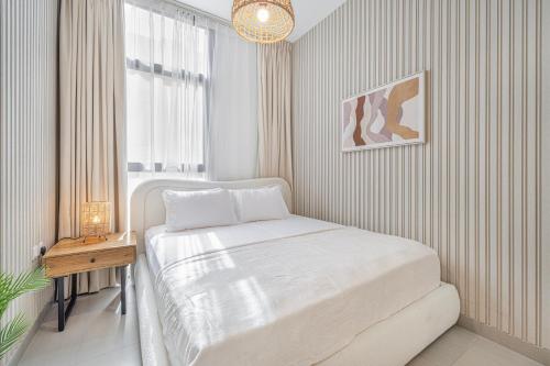 a white bedroom with a bed and a table at Private 1-Bedroom with living room apartment - Royal Suite in Sharjah Intl