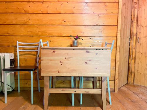 a wooden table with two chairs and a wooden wall at Le sorgenti - Chalet 57 in Palazzuolo sul Senio