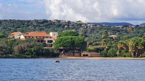 une maison au bord d'un plan d'eau dans l'établissement Appt T2, terrasse, Piscine, accès plage, à Pianottoli-Caldarello