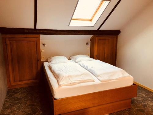 a bed in a room with a skylight at Appart Hotel Au Pied de Vigne in Vresse-sur-Semois