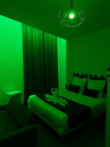 a green room with two beds and a couch at Studio Cosy Toulon Centre in Toulon