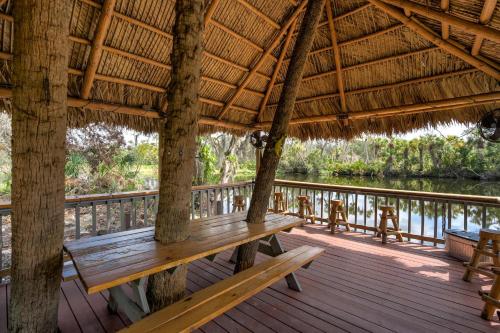 a wooden porch with a bench on a deck at Riverside Luau Tiki Hut Fire Pit & Outdoor Fun in Bradenton