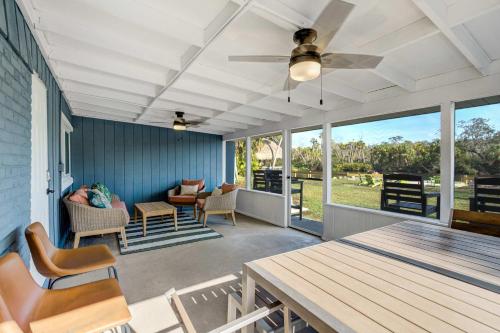 a screened in porch with a table and chairs at Riverside Luau Tiki Hut Fire Pit & Outdoor Fun in Bradenton