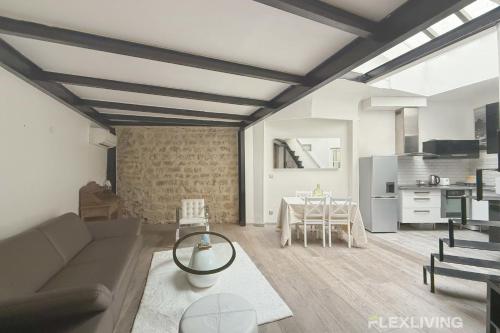 un salon avec un canapé et une table dans l'établissement Flexliving - T2 - Villiers, à Paris