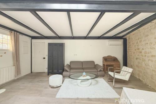 un salon avec un canapé et une table dans l'établissement Flexliving - T2 - Villiers, à Paris