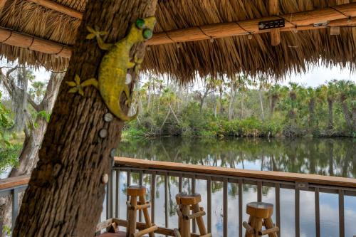 a view of a river from a porch with two stools at Riverside Breeze Tropical Retreat w Tiki Hut&BBQ in Bradenton