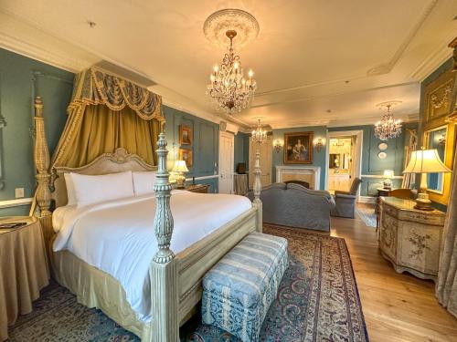 a bedroom with a large bed and a chandelier at The Chanler at Cliff Walk in Newport