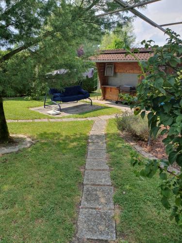 a garden with a stone path in front of a house at Le petit chalet de campagne in Richeling