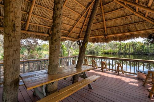a wooden porch with a bench on a deck at Riverside Breeze Tropical Retreat w Tiki Hut&BBQ in Bradenton