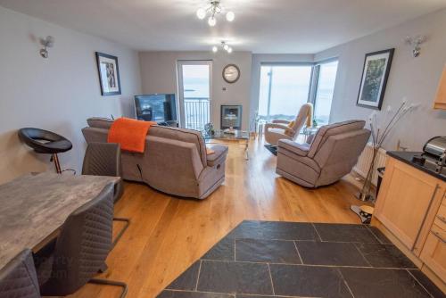 Una sala de estar con un sofá y sillas y un televisor. en 7 Morelli Plaza, en Portstewart