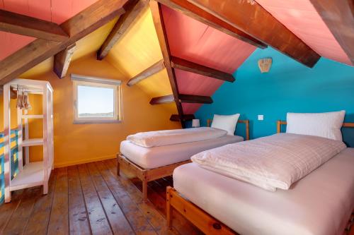 two beds in a room with a roof at Quinta da Estrela in Ponte Nova