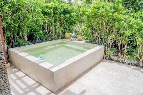 a hot tub in the middle of a garden at Xeliter Balcones del Atlantico - Las Terrenas in Las Terrenas