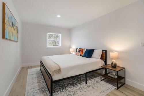 a white bedroom with a bed and a table at Riverside Hut Cozy Getaway w Tiki Hut & Grill in Bradenton