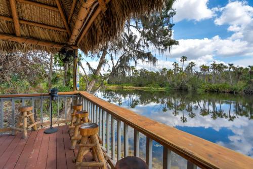 a porch with stools and a view of a river at Riverside Hut Cozy Getaway w Tiki Hut & Grill in Bradenton