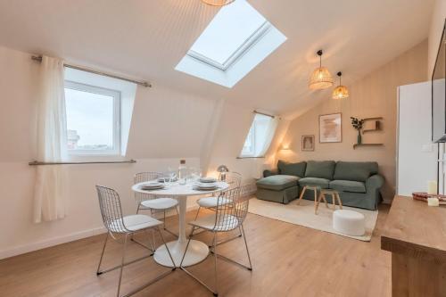 un salon avec une table, des chaises et un canapé dans l'établissement Appartement deux chambres sur la place Sébastopol, à Lille