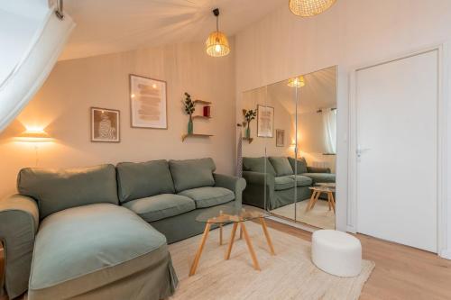 - un salon avec un canapé vert et un miroir dans l'établissement Appartement deux chambres sur la place Sébastopol, à Lille
