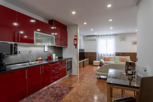 a kitchen with red cabinets and a living room at Bandeira'S house in Antuã