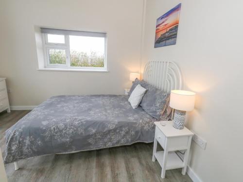 a bedroom with a bed and a table with a lamp at Coastguard View in Portland