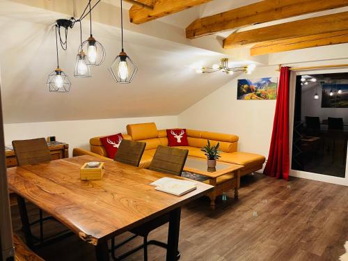 a dining room with a wooden table and a couch at Landhaus „Divija Haus“ Ferienwohnung in Pfronten