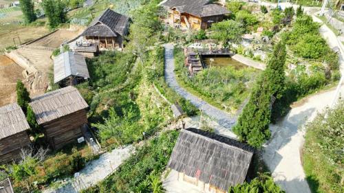 an aerial view of a village with houses and a river at Rose Farm Sa Pa in Sapa