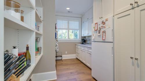 a kitchen with white cabinets and a refrigerator at Luxury Family Home with Pool and Spa, Screened Porch, Close to Beach in Hilton Head Island