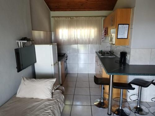 a small kitchen with a refrigerator and a table at Panorama home 19 in Graskop