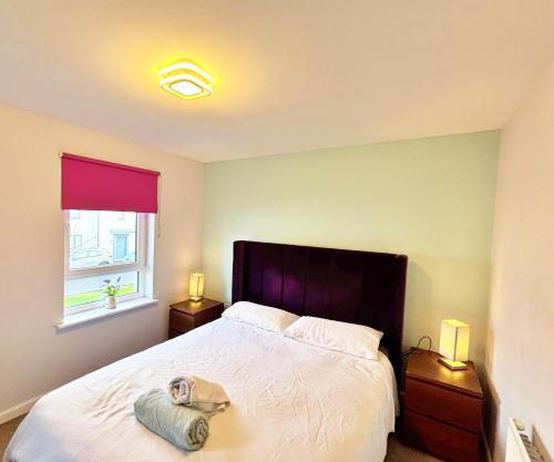 a bedroom with a bed with a hat on it at 3 bed house with parking near airport in Edinburgh