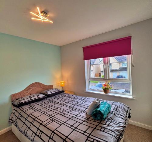 a bedroom with a bed and a window at 3 bed house with parking near airport in Edinburgh