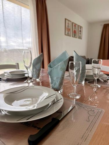 - une table en bois avec une assiette et des verres à vin dans l'établissement Les gîtes Pléhédelais TER, à Pléhédel