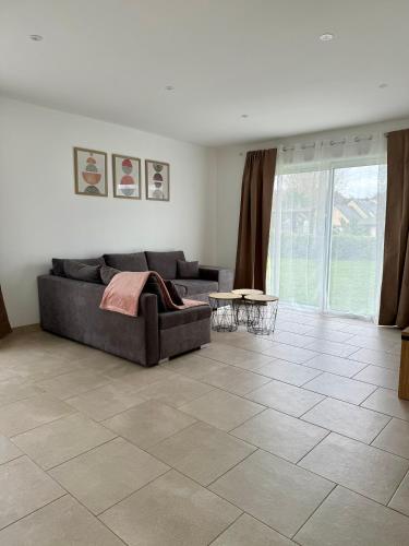 - un salon avec un canapé et du carrelage dans l'établissement Les gîtes Pléhédelais TER, à Pléhédel